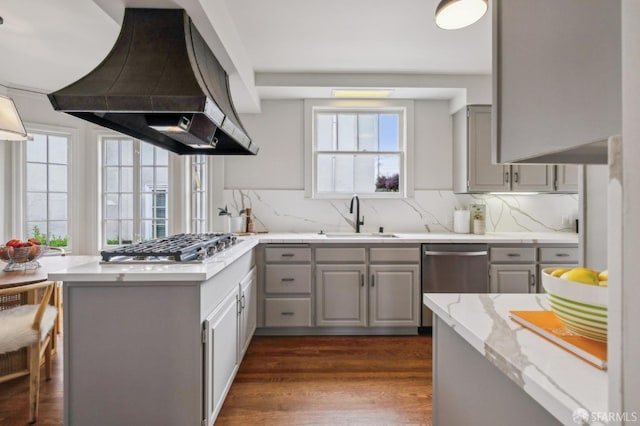 kitchen with gray cabinets, a peninsula, extractor fan, stainless steel appliances, and a sink