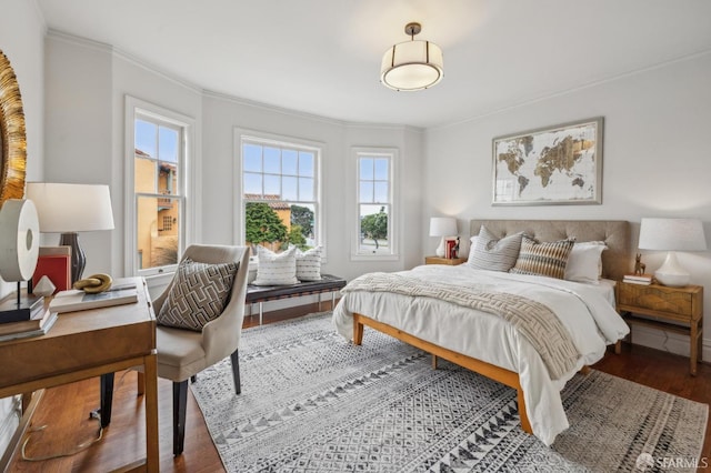 bedroom featuring wood finished floors and ornamental molding