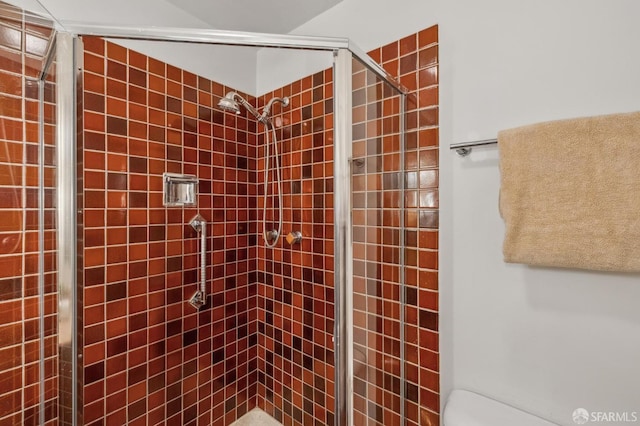 bathroom with a shower stall and toilet