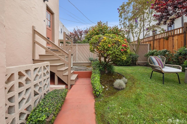 view of yard featuring fence and stairway