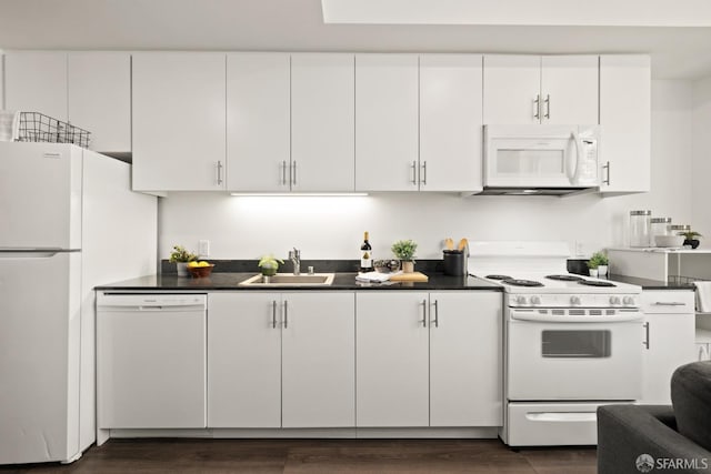 kitchen with white appliances, sink, dark wood-type flooring, and white cabinets