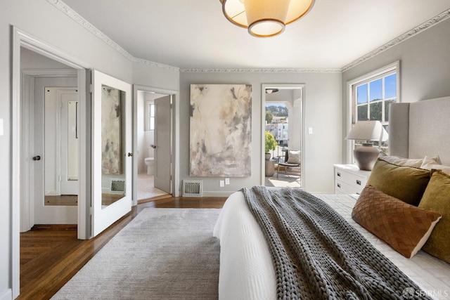 bedroom with crown molding, dark wood-type flooring, and connected bathroom