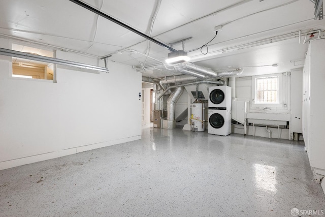 basement featuring gas water heater, stacked washer and dryer, and heating unit