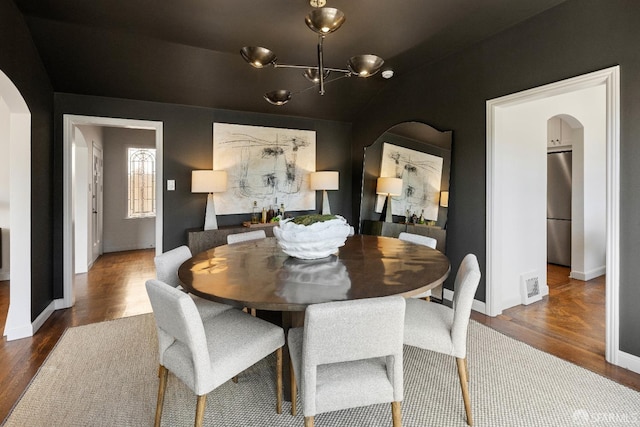 dining room featuring an inviting chandelier and dark wood-type flooring