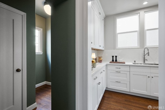 kitchen with white cabinets, a healthy amount of sunlight, sink, and dark wood-type flooring