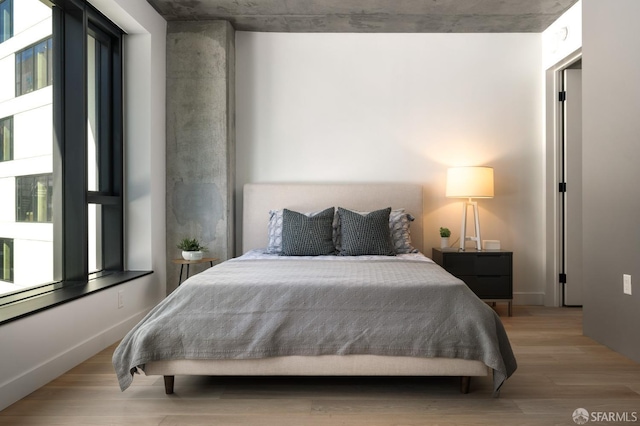 bedroom with multiple windows and light wood-type flooring