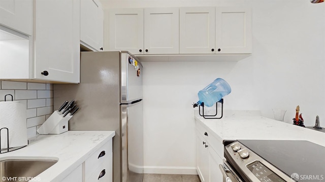 460 N Civic Dr Unit 317, Walnut Creek, CA 94596 - kitchen featuring white cabinets, baseboards, light stone counters, and decorative backsplash