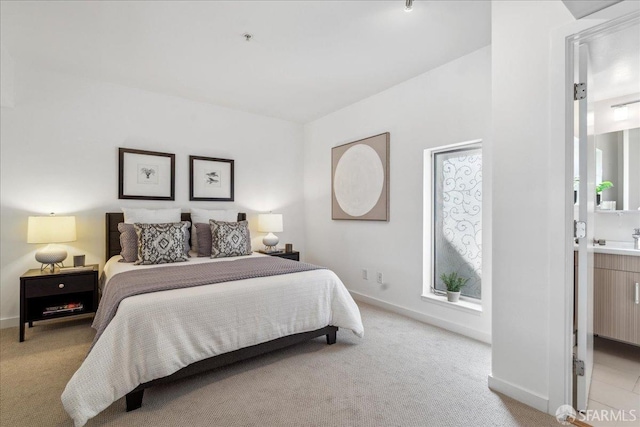 bedroom with light colored carpet and baseboards