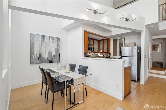 dining room featuring light wood-style flooring and baseboards