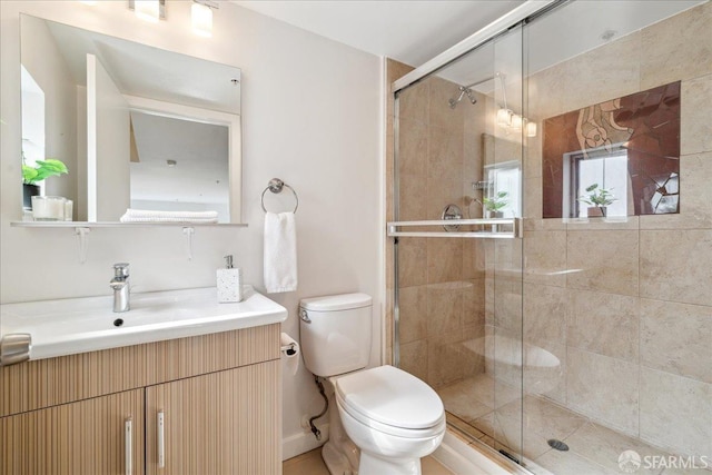 bathroom with a stall shower, toilet, and vanity