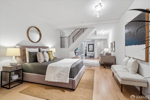 bedroom featuring wood finished floors and a textured ceiling