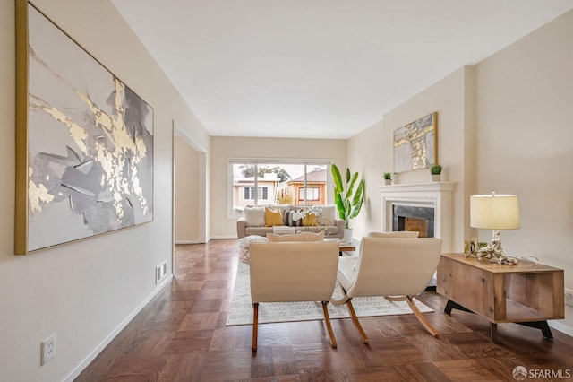 living area featuring a premium fireplace, baseboards, and visible vents