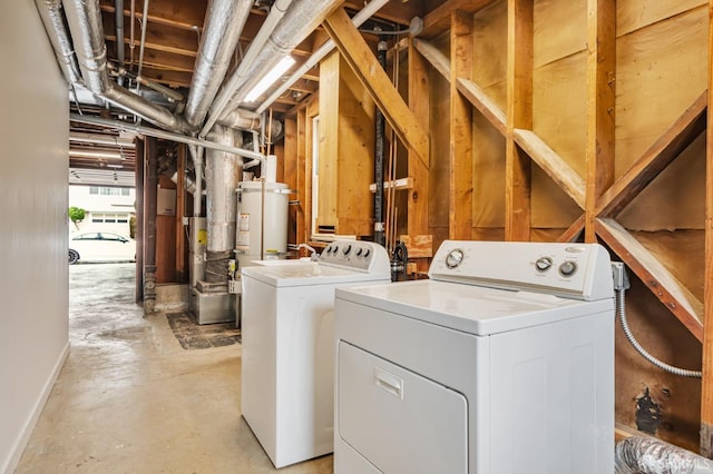 laundry area with strapped water heater, washing machine and dryer, and laundry area