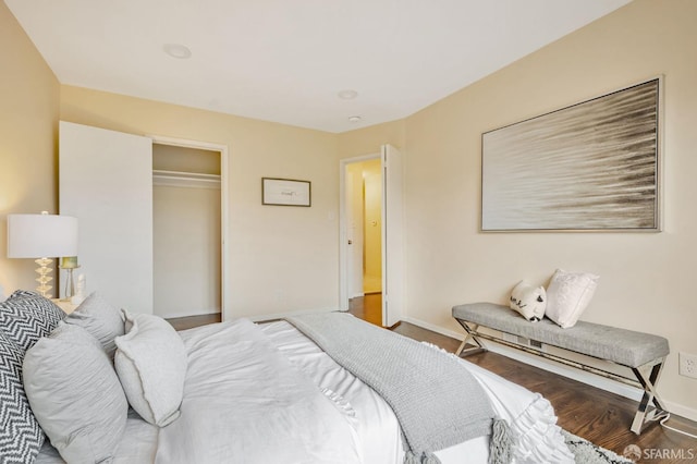 bedroom with a closet, baseboards, and wood finished floors