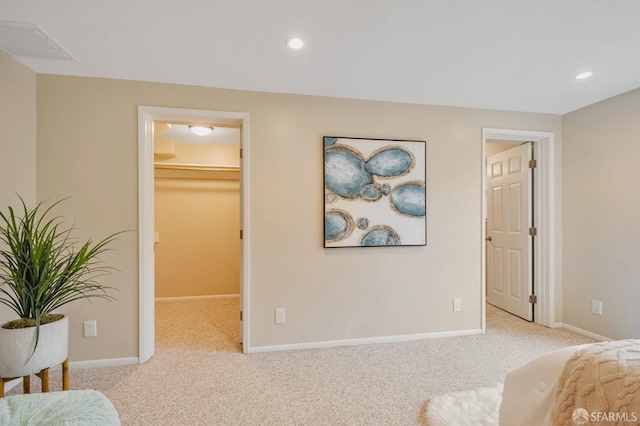 carpeted bedroom featuring a walk in closet, recessed lighting, baseboards, and visible vents