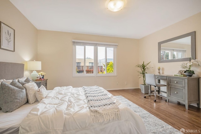 bedroom with baseboards and wood finished floors