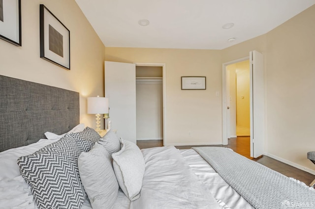 bedroom featuring a closet, baseboards, and wood finished floors