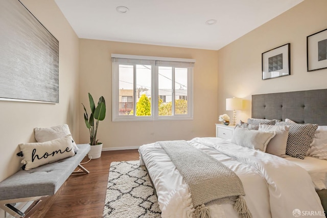 bedroom featuring baseboards and dark wood-style flooring