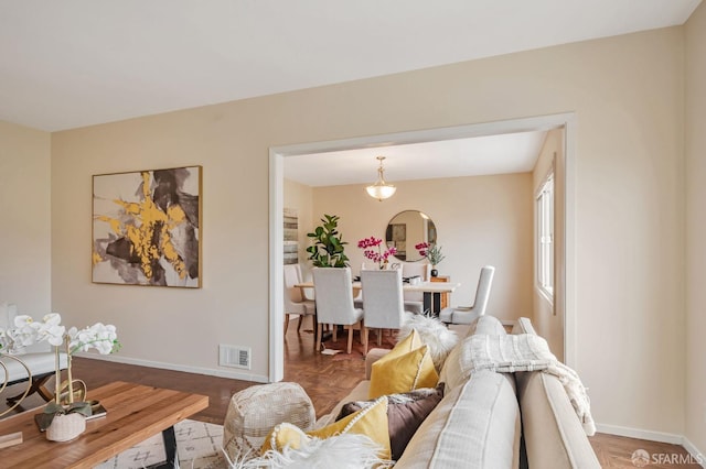 living area featuring baseboards and visible vents