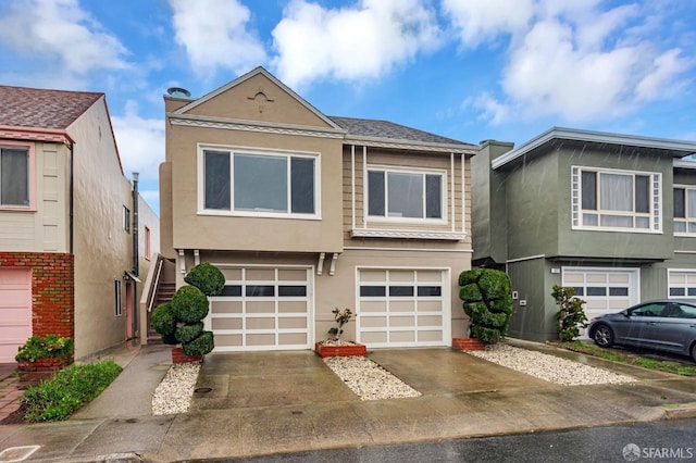 multi unit property with a garage, driveway, and stucco siding