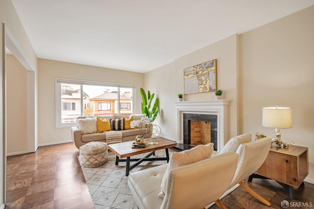 living room with a fireplace with flush hearth and baseboards