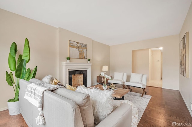 living room with a fireplace and baseboards