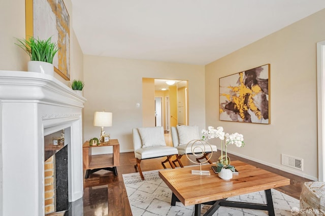 living room with a fireplace, visible vents, and baseboards