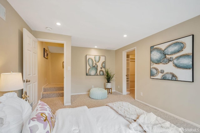 carpeted bedroom with a walk in closet, visible vents, recessed lighting, a closet, and baseboards