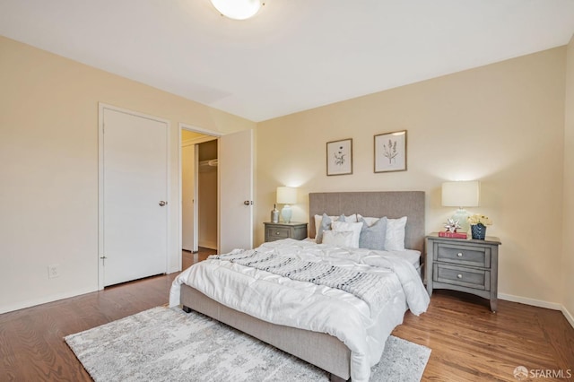 bedroom with baseboards and wood finished floors