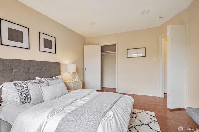 bedroom featuring a closet, baseboards, and wood finished floors