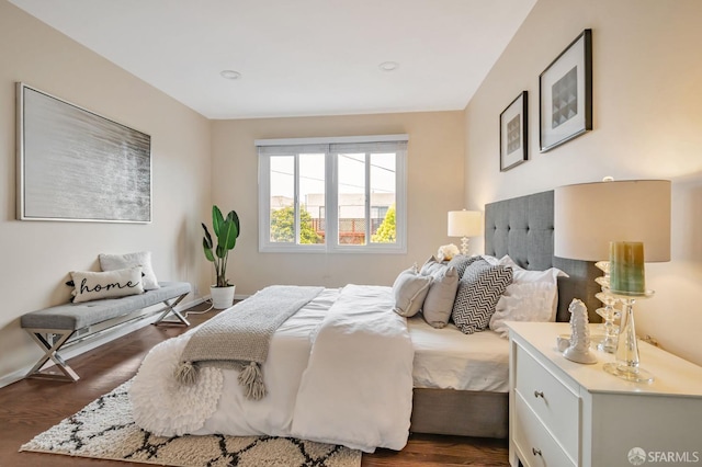 bedroom with baseboards and dark wood-type flooring