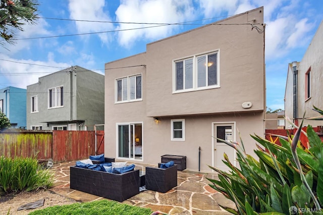 back of house with an outdoor living space, stucco siding, fence, and a patio area