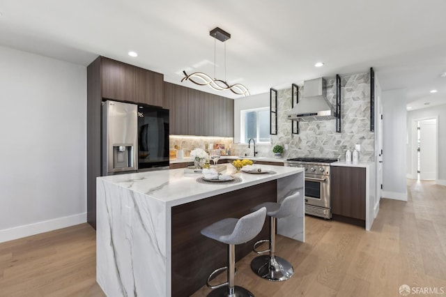 2055 42nd Ave, San Francisco, CA 94116 - kitchen featuring wall chimney range hood, high end range, modern cabinets, a breakfast bar, and backsplash