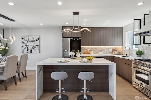 2055 42nd Ave, San Francisco, CA 94116 - kitchen featuring high end stove, modern cabinets, a kitchen island, a breakfast bar area, and recessed lighting