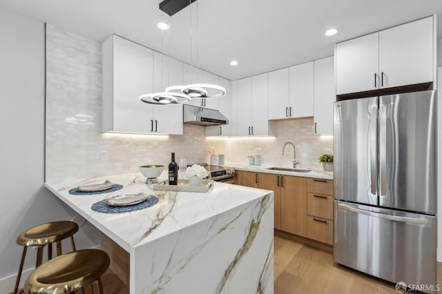 2055 42nd Ave, San Francisco, CA 94116 - kitchen featuring stainless steel appliances, under cabinet range hood, light wood-type flooring, a peninsula, and a breakfast bar