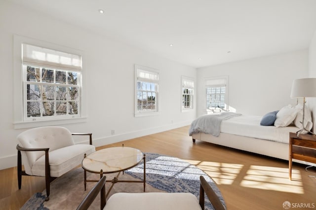 bedroom with recessed lighting, wood finished floors, and baseboards