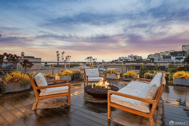 wooden terrace with an outdoor fire pit and a city view