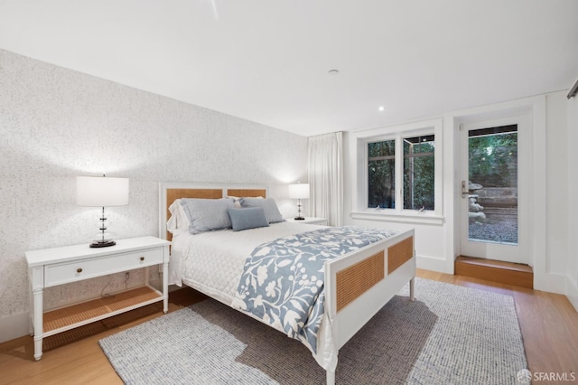 bedroom featuring wallpapered walls and wood finished floors