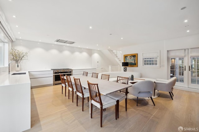 dining area with recessed lighting, stairway, light wood-style flooring, and french doors