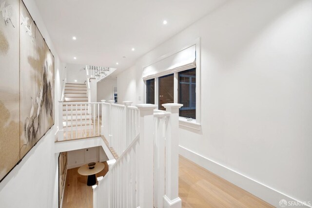 staircase featuring baseboards, wood finished floors, and recessed lighting