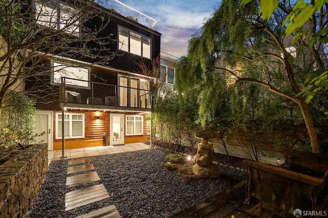 back of property featuring a patio area and a balcony