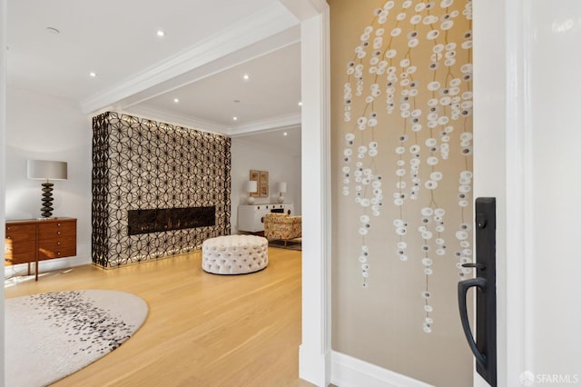 interior space featuring recessed lighting, crown molding, wood finished floors, and a tile fireplace