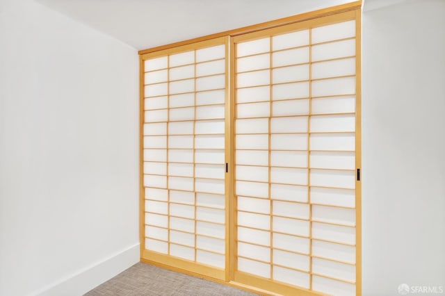 empty room featuring baseboards and light colored carpet