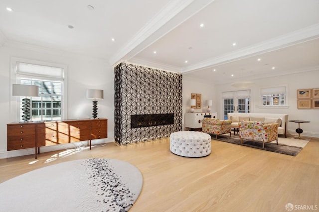 living area with baseboards, a fireplace, wood finished floors, and crown molding