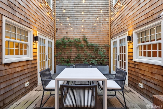 wooden terrace featuring french doors and outdoor dining area