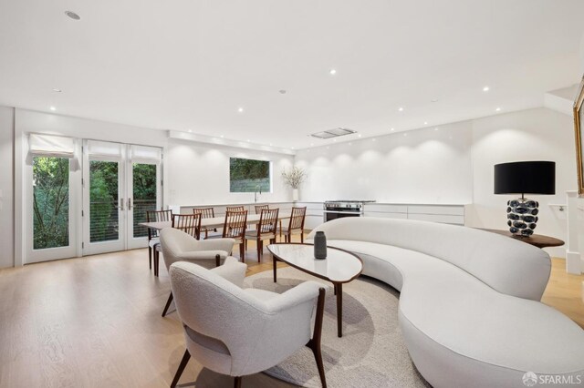 living room with french doors, light wood finished floors, and recessed lighting