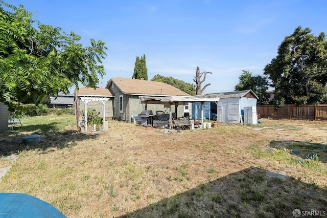 2340 Cooley Ave, East Palo Alto, CA 94303 - rear view of house with a pergola, fence, and an outdoor structure