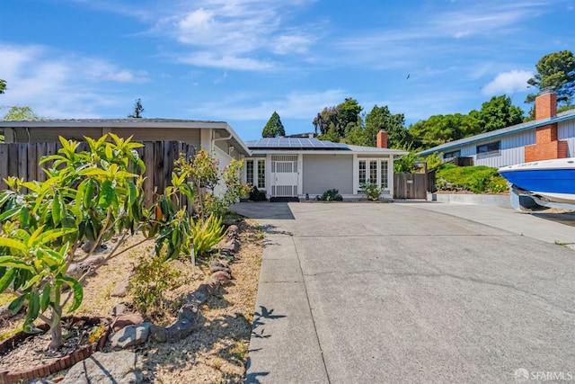 2675 Simas Ave, Pinole, CA 94564 - single story home featuring solar panels, concrete driveway, a chimney, and a gate