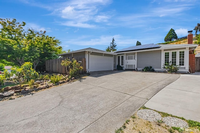 2675 Simas Ave, Pinole, CA 94564 - ranch-style house with an attached garage, driveway, solar panels, and a chimney