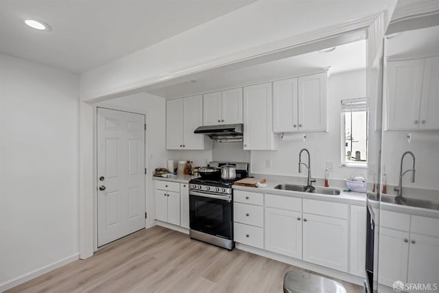 2675 Simas Ave, Pinole, CA 94564 - kitchen featuring gas range, light wood-style floors, white cabinets, under cabinet range hood, and light countertops